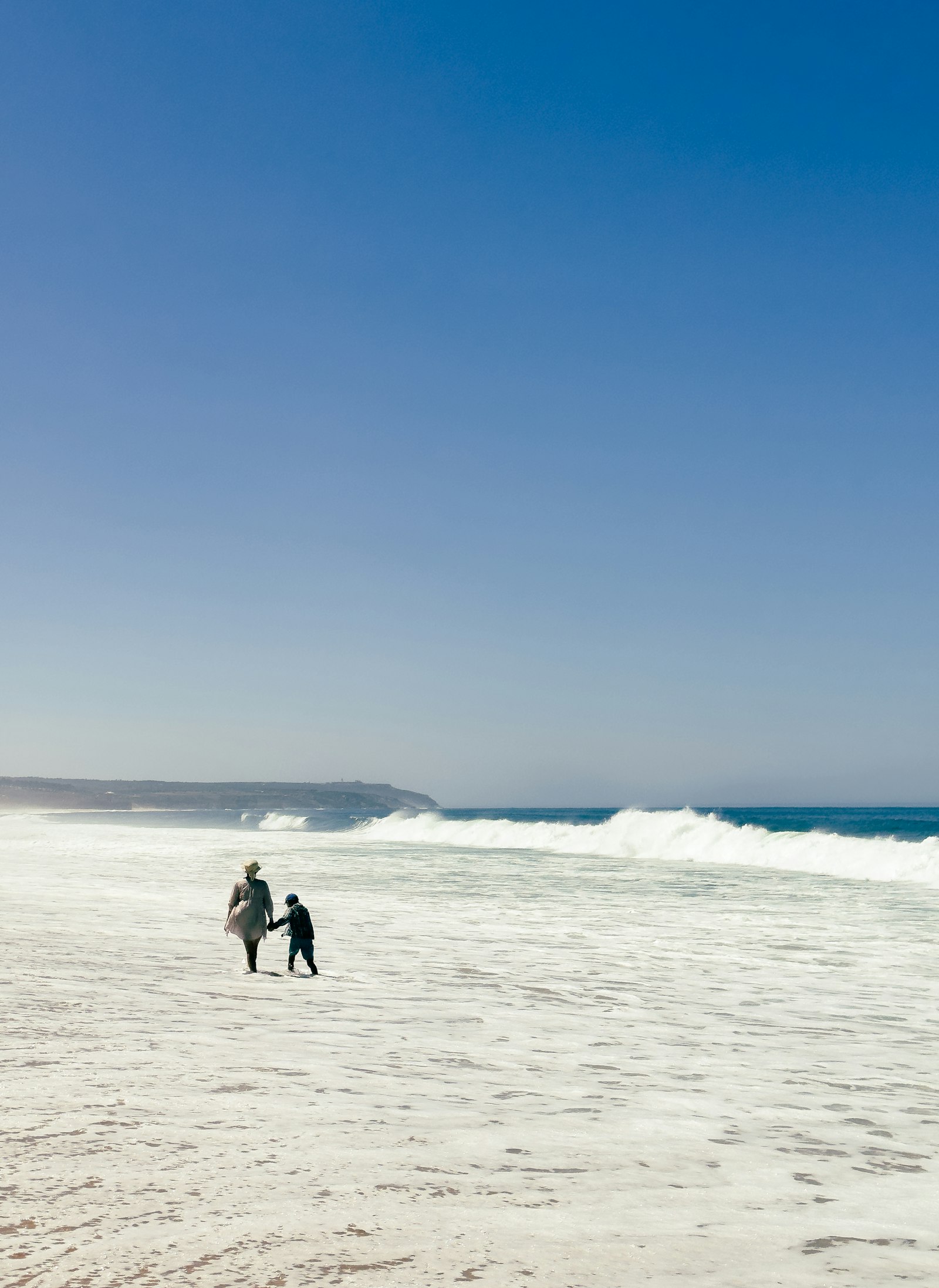 Mother and child in the surf on a Silver Coast beach near Caldas da Rainha